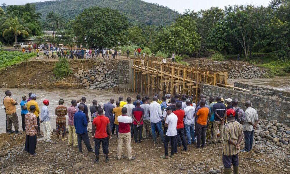 Habitants et équipes de chantier mobilisés autour du pont en construction sur la rivière Sikaly à Dhaguel