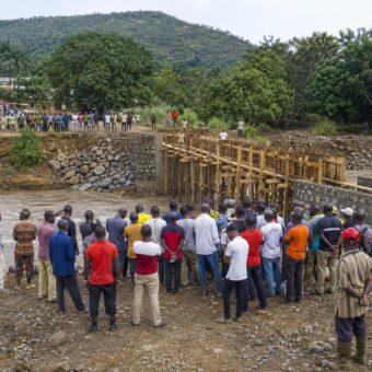 Habitants et équipes de chantier mobilisés autour du pont en construction sur la rivière Sikaly à Dhaguel
